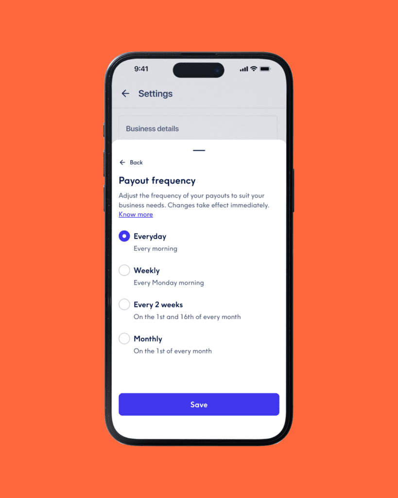 Primo piano dello schermo di uno smartphone su sfondo arancione acceso, che mostra il menu delle impostazioni "Payout frequency" (Frequenza dei pagamenti). L'opzione selezionata è "Everyday" (Ogni giorno), con altre opzioni non selezionate per "Weekly", "Every 2 weeks" e "Monthly". In basso è presente un pulsante blu "Save".